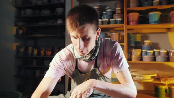 Young Handsome Artist Operates Hands Which Gently Creating Correctly Shaped Handmade From Clay