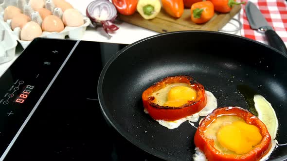 Preparation Fried Eggs in Ring of Bell Pepper and Sprigs Rosemary and Thyme on Frying Pan