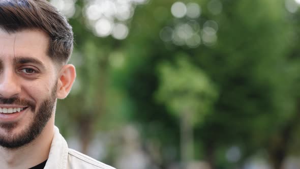 Half Face of Bearded Man With Brown Eye Looking to Camera Smiling While Standing Outdoor