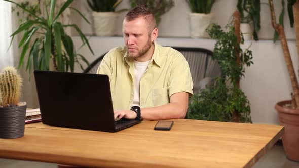 Freelancer Man Working with Laptop on the Table at Home