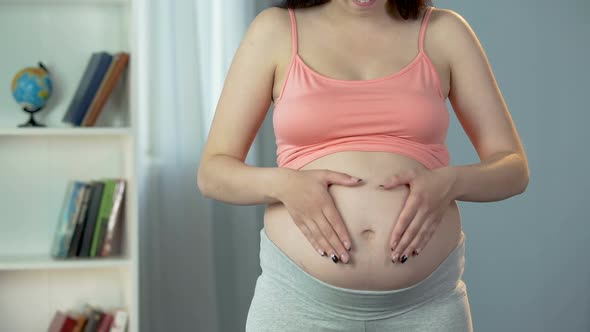 Pregnant Lady Making Heart Shape Sign With Hands on Big Belly, Love for Baby