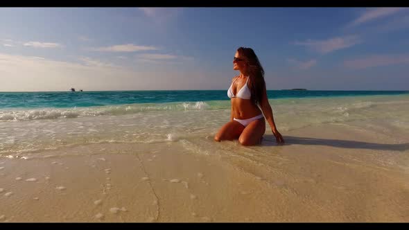 Lady sunbathing on tranquil shore beach holiday by blue sea and white sand background of the Maldive