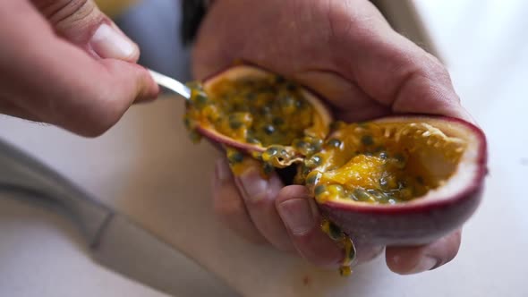 Unrecognizable Man Eating Passion Fruit with Spoon Indoors