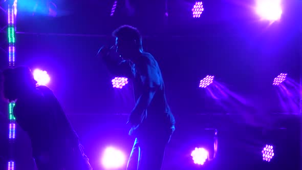 Silhouettes of a Talented Young Girl and Boy Hip Hop Dancers. Hip Hop Street Dance on a Stage in