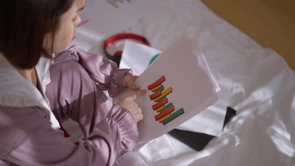 High Angle View Business Graphs in Hands of Concentrated Intelligent Little Woman Analyzing Project