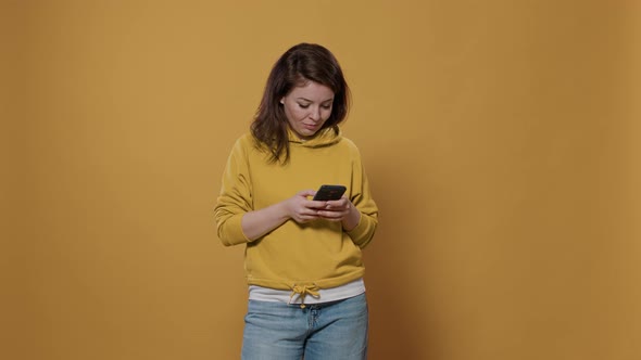 Portrait of Casual Woman Holding Smartphone Texting Having Funny Online Conversation on Social Media