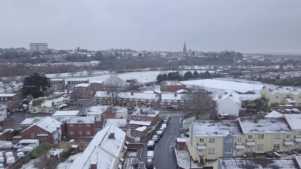 Ascending drone shot of a snowy Exeter looking towards the town centre