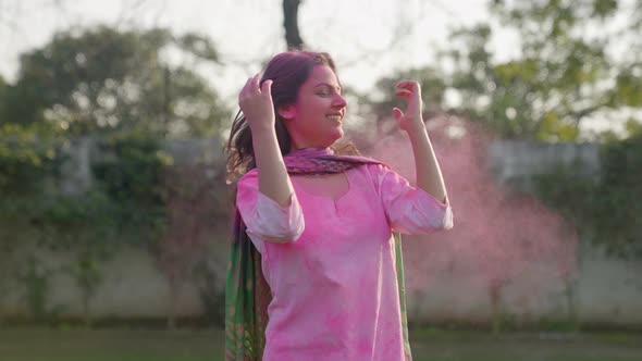 Indian girl enjoying Holi festival and playing with her hairs