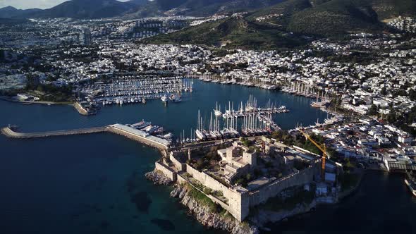 View from drone on full of yachts Bodrum harbour and ancient Kalesi castle in Mugla in Turkey