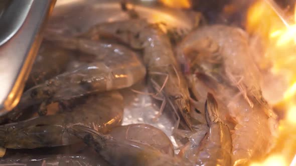 Chef Puts Raw Shrimps Into Frying Pan with Garlic and Thyme