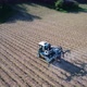 Aerial view of tractor spraying pesticides or water on field with sprayer at spring - VideoHive Item for Sale