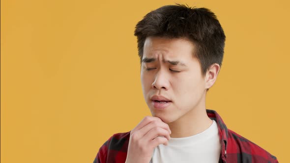 Asian Guy Thinking About Problems And Frowning Over Yellow Background