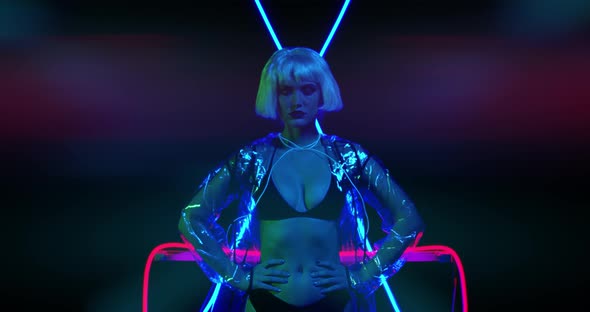 Sexy Young Woman in Black Lingerie and Transparent Coat Is Posing in Neon Light