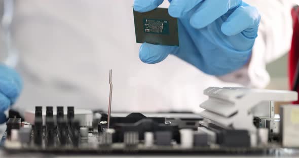 Gloved Engineer Inserts Microcircuit Into Motherboard