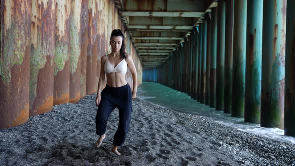 Sexy Lady is Dancing on Shore of Sea Under Pier Moving Sexually Dance Performance