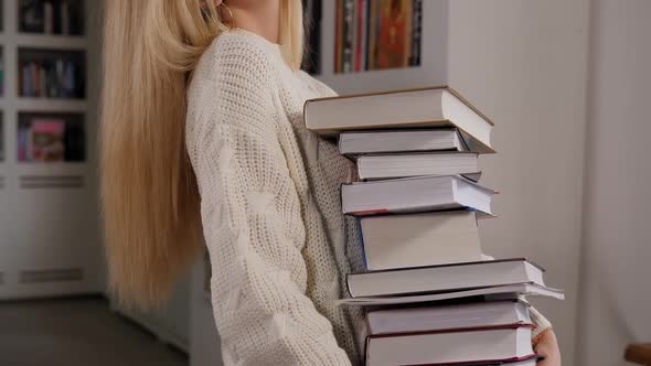 Girl Student Holding a Lot of Books in the Library Preparing for Exams