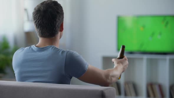 Bachelor Watching Football Match Supporting National Team, Drinking Beer on Sofa