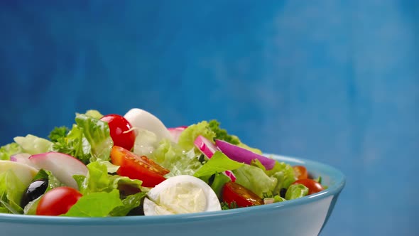 Mayonnaise sauce pouring onto vegetable salad, salad dressing