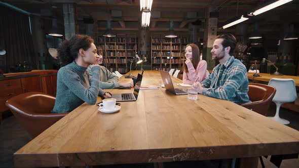 Group of Diverse Young Colleagues Discuss Plans at Conference Table