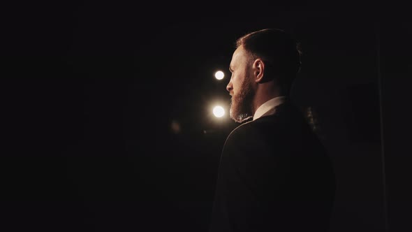 A Man is Standing on the Stage and Looking Into the Audience