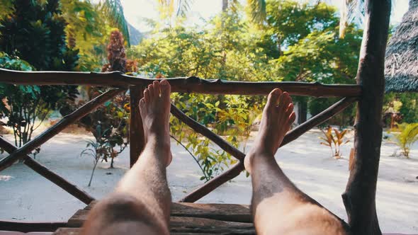 POV of Man Legs on the Tropical Hotel Veranda Summer Vacation Zanzibar Africa