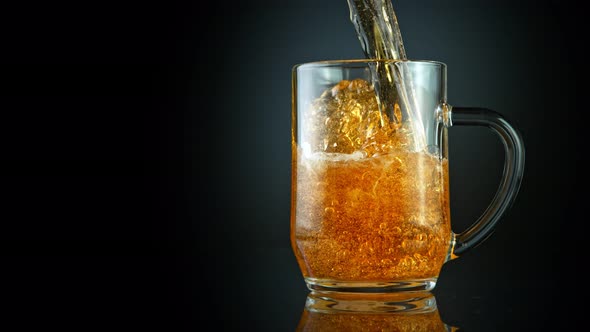 Super Slow Motion Shot of Pouring Fresh Beer Into Glass on Black Background at 1000Fps