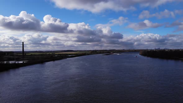 Cloudscape Over Serene River Of Oude Maas Near Riverbanks Of Puttershoek Town In Western Netherlands