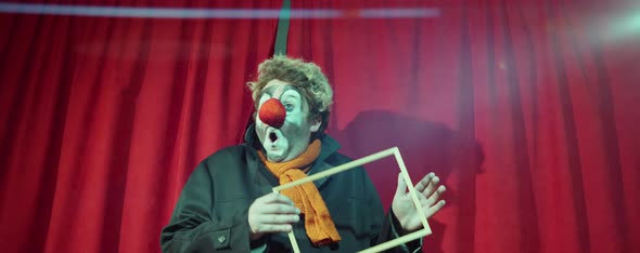 Clown Performing Comedy with Wooden Frame on Stage