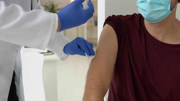 Doctor Giving Covid19 or Flu Antivirus Vaccine Shot to Young Male Patient Wear Face Mask Protection