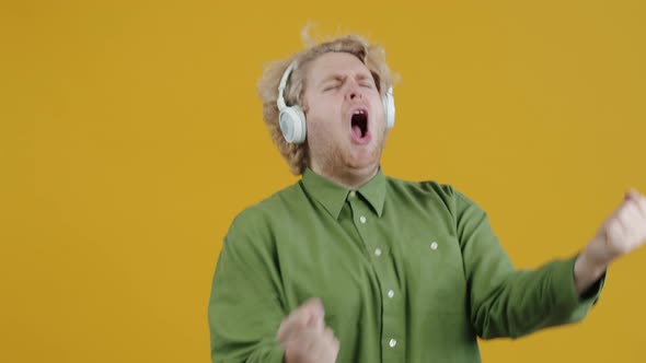 Portrait of Creative Young Man Singing and Dancing Listening to Music with Headphones