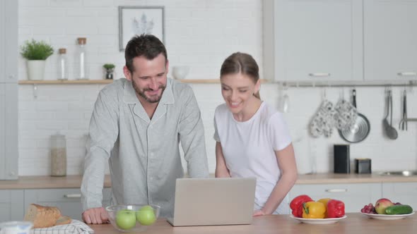 Woman and Man Doing Video Call on Laptop in Kitchen