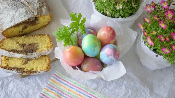 Easter Eggs in a Bowl with a Home Baked Cake and Pots of Flowers Flat Lay