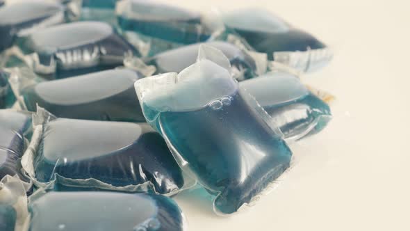 Liquid ultra-concentrated detergent slow tilt 4K 2160p 30fps UltraHD footage -Blue laundry pods on w alt