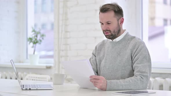 Man Upset After Reading Documents at Work