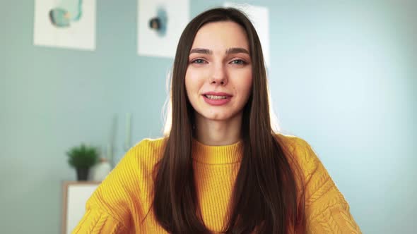 Happy Woman in Yellow Sweater Smiling and Chatting on Webcam with Her Followers