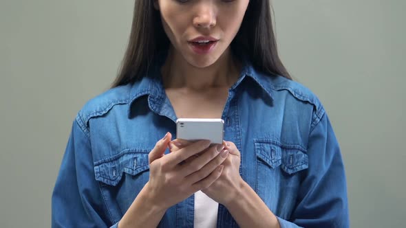 Asian Woman Reading E-Mail on Smartphone and Showing Yes Sign, Job Confirmation