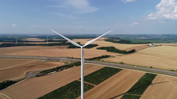Large Wind Turbines with Blades in Field Aerial View Bright Orange Sunset Blue Sky Wind Park Slow