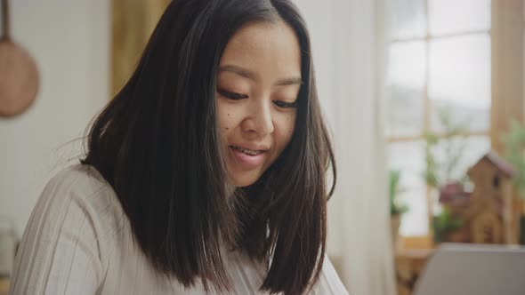 Smiling Asian Woman Portrait with Braces While Working on Her Laptop in Slow Motion