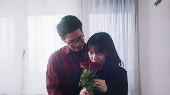 Young Asian Man Giving Red Roses to His Girlfriend