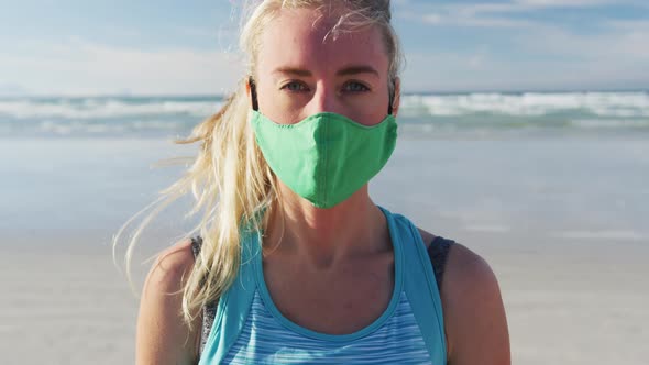 Portrait of caucasian woman wearing face mask at the beach