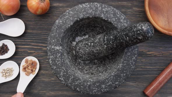 Top View of Salt Brown Sugar and Peppercorns Falling Into the Grey Stone Mortar