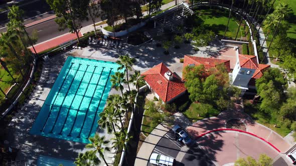 Aerial drone rotation shot from community pool to park baseball field.