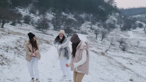 Group of Three Happy Friends Having Fun and Playing with Snow in Winter Park