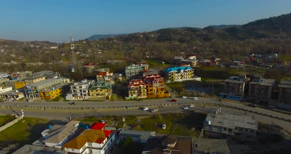 A city drone shot with road and houses.