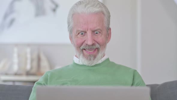 Close Up of Old Man Celebrating Success on Laptop