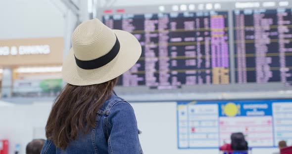 Woman look at the schedule board in the airport