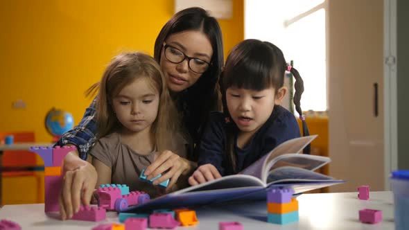 Lovely Daycare Teacher Working with Pupils at Class