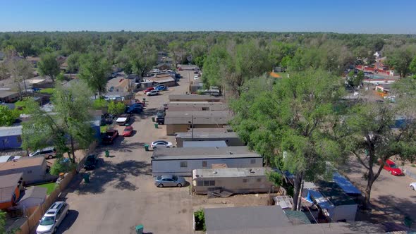 A drone shot of a high rising shot in a poor trailer park. 2021 4k, 60fps.