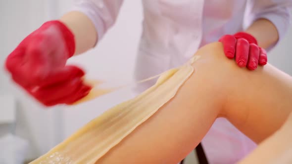 Process of Legs Depilation By Sugar for Women in Beauty Salon