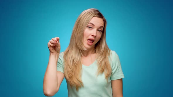 Young Bored Woman Making Blahblah Gesture with Hand Against Blue Background